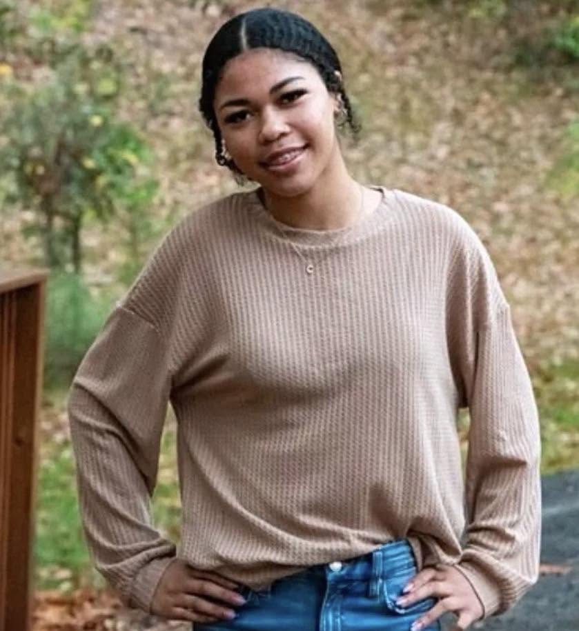 Kayla standing outdoors on a wooden deck