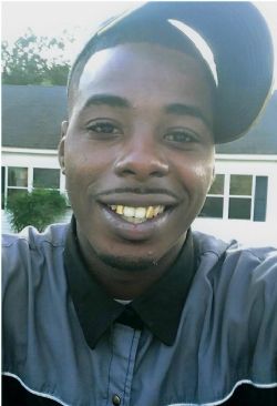 Marquis Martin smiling, wearing a sideways cap and tie