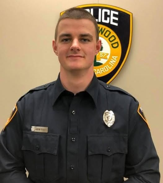 Austin Teasley, pictured in uniform in front of a Greenwood Police emblem